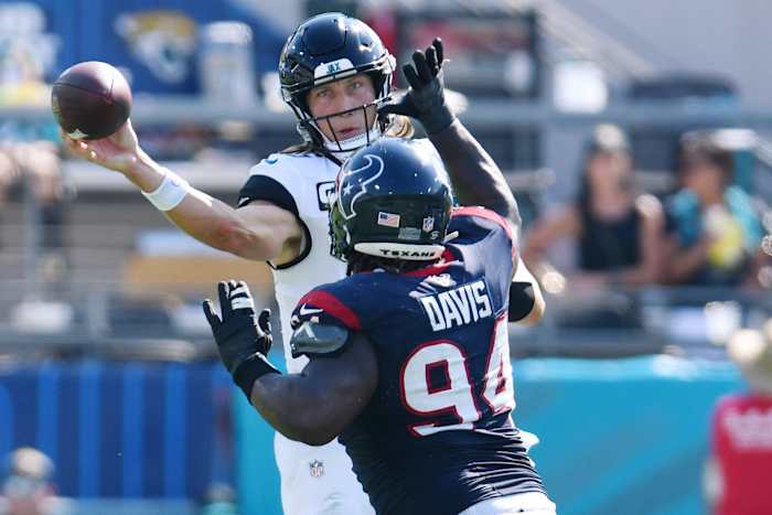 Jaguars quarterback Trevor Lawrence launches a pass to while being pressured by Houston Texans defensive tackle Khalil Davis.